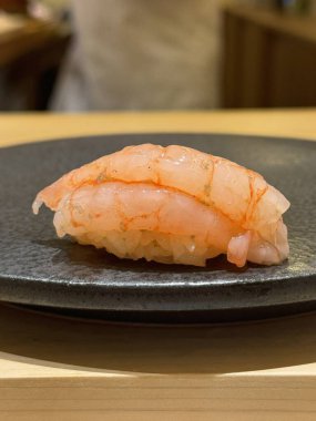 Çeşitli malzemeler ve canlı renklerle sanatsal olarak düzenlenmiş taze suşi çeşitleri. Bu geleneksel Japon yemeği bir deneyim için sirkeli pirinç, deniz ürünleri ve sebzeleri birleştirir..