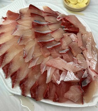 Taze ve narin sashimi dilimleri, canlı renkler ve mükemmel kesimlerle güzelce sunuluyor. Bu geleneksel Japon lezzeti kaliteli deniz ürünlerinin saf tatlarını vurgular..