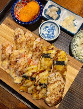 Çeşitli malzemeler ve canlı renklerle sanatsal olarak düzenlenmiş taze suşi çeşitleri. Bu geleneksel Japon yemeği bir deneyim için sirkeli pirinç, deniz ürünleri ve sebzeleri birleştirir..