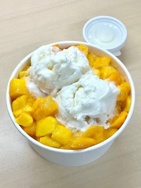 Tüylü buzlu mango bingsu, tatlı mango parçaları ve yoğun sütlü krema. Sıcak günler için mükemmel bir Kore tatlısı, lezzetli meyveli ve kremalı tatlar dengesi sunuyor.!