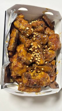 Kızarmış Kore tavuğu, tatlı ve baharatlı sosla mükemmel bir şekilde jölelenmiş. Yemek fotoğrafçılığı ve menüler için idealdir. Bu sevilen yemeğin dayanılmaz çıtırtısını ve lezzetini sergiler..