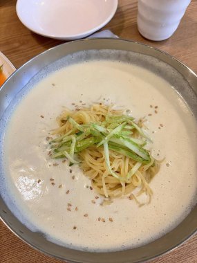 Kungguksu, taze sebzelerle kaplanmış ve yosunlarla süslenmiş lezzetli bir Kore soğuk şehriye çorbası. Yaz yemekleri için mükemmel, Kore konforlu yiyeceklerinin özünü yakalamak için..