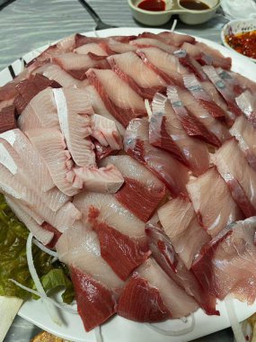 Taze ve narin sashimi dilimleri, canlı renkler ve mükemmel kesimlerle güzelce sunuluyor. Bu geleneksel Japon lezzeti kaliteli deniz ürünlerinin saf tatlarını vurgular..