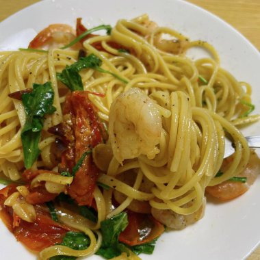 Bir tabak spagetti makarnası, mükemmel pişirilmiş ve üzerine bol marinara sosu ve taze otlar konmuş. Yemek fotoğrafçılığı ve menüler için ideal, İtalyan mutfağının kalbini lezzetli bir şekilde yakalamak..