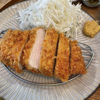 Çıtır tonkatsu, Japon usulü kızarmış domuz pirzolası dilimlenmiş lahana ve tuzlu sosla servis edilir. Lezzetli bir kıtır kıtır doku ve sulu et dengesi.