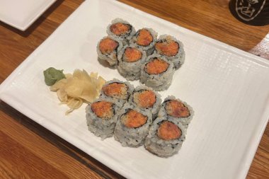 Çeşitli malzemeler ve canlı renklerle sanatsal olarak düzenlenmiş taze suşi çeşitleri. Bu geleneksel Japon yemeği bir deneyim için sirkeli pirinç, deniz ürünleri ve sebzeleri birleştirir..