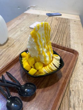 Tüylü buzlu mango bingsu, tatlı mango parçaları ve yoğun sütlü krema. Sıcak günler için mükemmel bir Kore tatlısı, lezzetli meyveli ve kremalı tatlar dengesi sunuyor.!