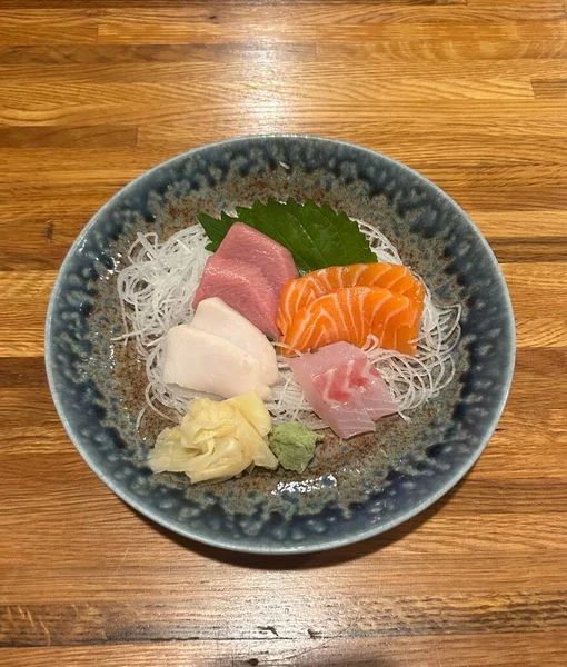 Taze ve narin sashimi dilimleri, canlı renkler ve mükemmel kesimlerle güzelce sunuluyor. Bu geleneksel Japon lezzeti kaliteli deniz ürünlerinin saf tatlarını vurgular..