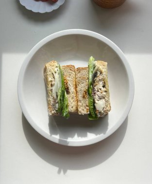 Çıtır sebzeler, taze etler ve iki dilim yumuşak ekmek arasında baharatlı yayılan baharatlı sandviçlerle dolu lezzetli bir sandviç. Hızlı ve tatmin edici bir yemek için mükemmel..