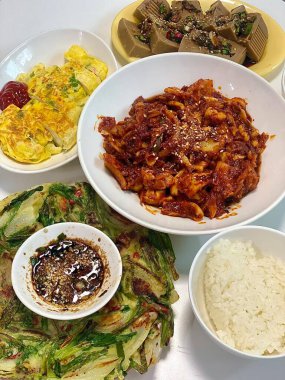 Warm and comforting jibbap (home-cooked Korean meal) with a spread of rice, soup, and banchan, offering a perfect harmony of flavor, tradition, and heartwarming nourishment in every bite.