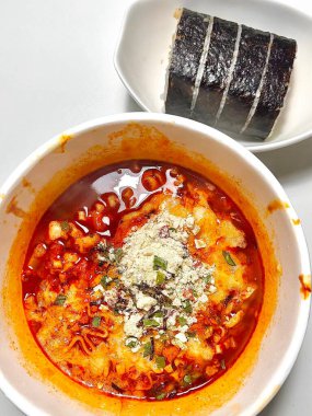 Taze kimbap ve keskin kimchi ile servis edilen kalın ve lezzetli bir çorba ile baharatlı Shin Ramyeon. Her lokmada mükemmel bir teselli, lezzetli ve baharatlı Kore yemeği..