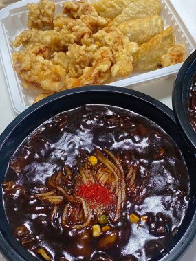 Zengin siyah fasulye sosuna bulanmış kalın, çiğnenmiş erişteli klasik Kore-Çin karışımı, yanında gevrek tangsuyuk, bol yağda kızartılmış domuz eti ve tatlı ve ekşi sos servis edilir..