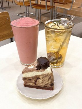 Hoş bir kafe ortamında sergilenen tatlı çeşitleri zarif tabaklar üzerinde pastalar, pastalar ve tatlı ikramlar, sıcak ve davetkar bir atmosfer yaratıyor..