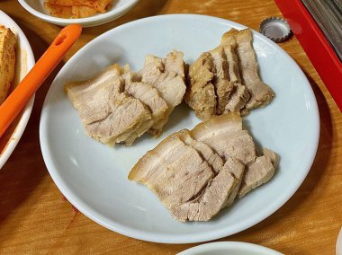 Suyuk, geleneksel Kore usulü haşlanmış domuz dilimleri, yumuşak ve sulu, genellikle tuzlu karides sosu, sarımsak ve ssamjang ile servis edilir. Lezzetli ve dengeli bir ısırık için salataya sarmak için mükemmel..