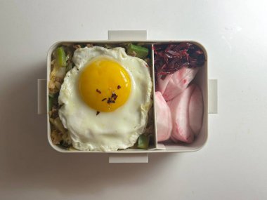 Bento or dosirak box filled with rice, assorted side dishes, vegetables, and protein like meat or fish, all neatly arranged to create a balanced, colorful, and visually appealing meal