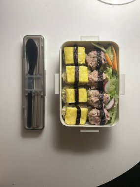 Bento or dosirak box filled with rice, assorted side dishes, vegetables, and protein like meat or fish, all neatly arranged to create a balanced, colorful, and visually appealing meal