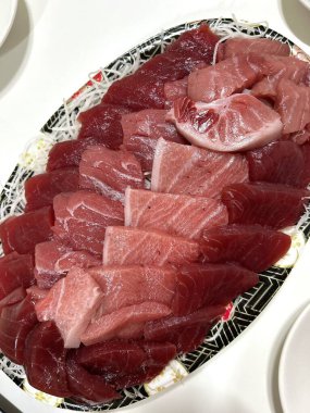 Taze ve narin sashimi dilimleri, canlı renkler ve mükemmel kesimlerle güzelce sunuluyor. Bu geleneksel Japon lezzeti kaliteli deniz ürünlerinin saf tatlarını vurgular..