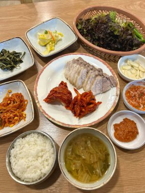 Yumuşak bir parça Bossam, Kore haşlanmış domuz göbeği, taze marul, sarımsak ve ssamjang ile servis edilir. Bu lezzetli ve lezzetli yemek geleneksel bir Kore yemeğini paketlemek ve paylaşmak için mükemmeldir..