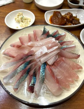 Taze ve narin sashimi dilimleri, canlı renkler ve mükemmel kesimlerle güzelce sunuluyor. Bu geleneksel Japon lezzeti kaliteli deniz ürünlerinin saf tatlarını vurgular..