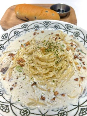 Lezzetli beyaz bir sosla kaplanmış kremalı ve zengin spagetti rahatlatıcı ve tatmin edici bir yemek için mükemmel bir lezzet sunuyor..