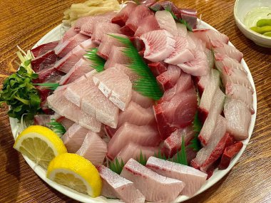 Taze ve narin sashimi dilimleri, canlı renkler ve mükemmel kesimlerle güzelce sunuluyor. Bu geleneksel Japon lezzeti kaliteli deniz ürünlerinin saf tatlarını vurgular..
