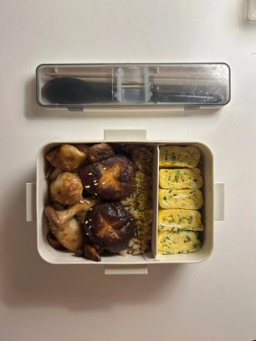 Bento or dosirak box filled with rice, assorted side dishes, vegetables, and protein like meat or fish, all neatly arranged to create a balanced, colorful, and visually appealing meal