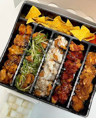 Kızarmış Kore tavuğu, tatlı ve baharatlı sosla mükemmel bir şekilde jölelenmiş. Yemek fotoğrafçılığı ve menüler için idealdir. Bu sevilen yemeğin dayanılmaz çıtırtısını ve lezzetini sergiler..