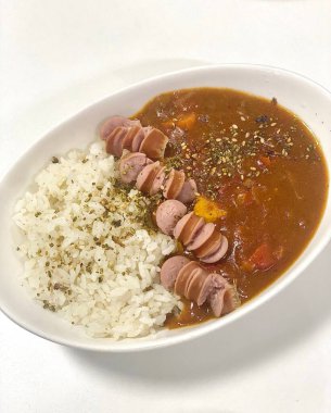 Yumuşak sebzeler ve et parçalarıyla dolu lezzetli bir sosun yer aldığı rahatlatıcı bir Japon köri kasesi yumuşak pirincin üzerine servis edilir. Her yemek için mükemmel, sıcak ve lezzetli bir yemek..