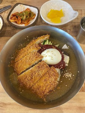 Soğuk naengmyeon erişteleri, dilimlenmiş sebze ve yumurtayla servis edilir. Çıtır çıtır altın donkatsu ile eşleştirilir. Bir öğünde ferahlatıcı ve lezzetli tatlar dengesi oluşturur.