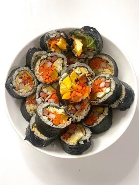 Taze sebzelerle, baharatlı pirinçlerle ve gevrek yosunlara sarılmış lezzetli proteinlerle dolu nefis kimbap dürümleri. Her ısırıkta lezzet ve dokuların mükemmel bir kombinasyonu.