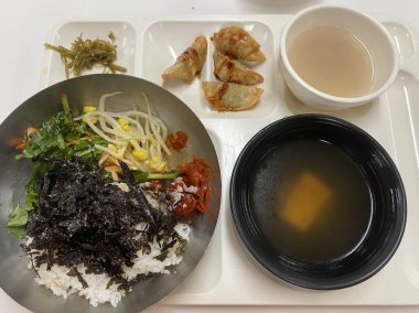 Bibimbap, çeşitli sebzeler, gochujang ve sıklıkla dilimlenmiş etin eşlik ettiği kızarmış yumurta ile süslenmiş canlı bir Kore pirinç yemeği. Karıştırıldığında, aromalı ve dengeli olur..