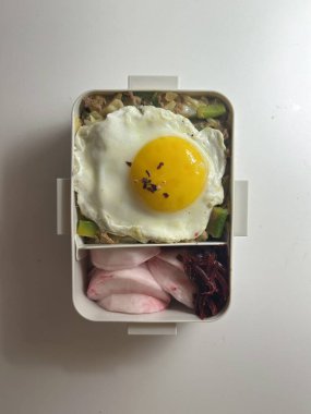 Bento or dosirak box filled with rice, assorted side dishes, vegetables, and protein like meat or fish, all neatly arranged to create a balanced, colorful, and visually appealing meal