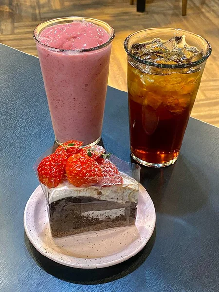 Hoş bir kafe ortamında sergilenen tatlı çeşitleri zarif tabaklar üzerinde pastalar, pastalar ve tatlı ikramlar, sıcak ve davetkar bir atmosfer yaratıyor..