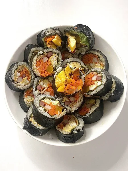 Taze sebzelerle, baharatlı pirinçlerle ve gevrek yosunlara sarılmış lezzetli proteinlerle dolu nefis kimbap dürümleri. Her ısırıkta lezzet ve dokuların mükemmel bir kombinasyonu.