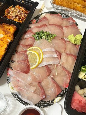 Taze ve narin sashimi dilimleri, canlı renkler ve mükemmel kesimlerle güzelce sunuluyor. Bu geleneksel Japon lezzeti kaliteli deniz ürünlerinin saf tatlarını vurgular..