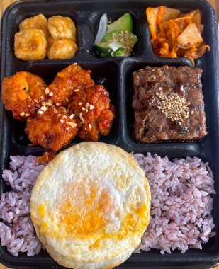 Bento or dosirak box filled with rice, assorted side dishes, vegetables, and protein like meat or fish, all neatly arranged to create a balanced, colorful, and visually appealing meal