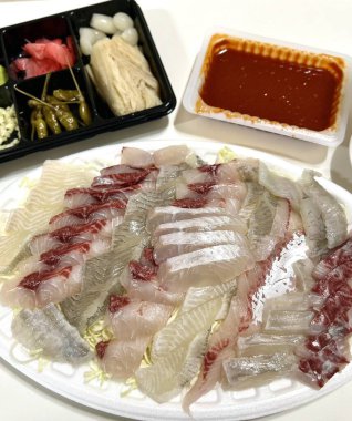 Taze ve narin sashimi dilimleri, canlı renkler ve mükemmel kesimlerle güzelce sunuluyor. Bu geleneksel Japon lezzeti kaliteli deniz ürünlerinin saf tatlarını vurgular..