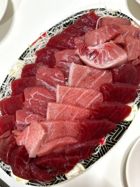 Taze ve narin sashimi dilimleri, canlı renkler ve mükemmel kesimlerle güzelce sunuluyor. Bu geleneksel Japon lezzeti kaliteli deniz ürünlerinin saf tatlarını vurgular..