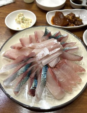 Taze ve narin sashimi dilimleri, canlı renkler ve mükemmel kesimlerle güzelce sunuluyor. Bu geleneksel Japon lezzeti kaliteli deniz ürünlerinin saf tatlarını vurgular..