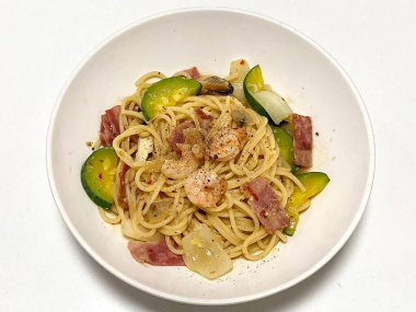 Bir tabak spagetti makarnası, mükemmel pişirilmiş ve üzerine bol marinara sosu ve taze otlar konmuş. Yemek fotoğrafçılığı ve menüler için ideal, İtalyan mutfağının kalbini lezzetli bir şekilde yakalamak..