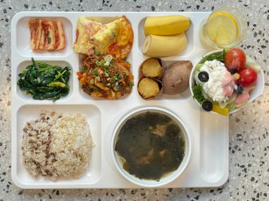 Masada kimçi, turşu sebze turşusu ve baharatlı sebzeler gibi çeşitli banchan (yan yemekler) içeren canlı bir Kore yemeği serpintisi. Yemek fotoğrafçılığı için mükemmel, geleneksel Korece sergileniyor..