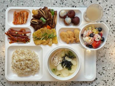 Masada kimçi, turşu sebze turşusu ve baharatlı sebzeler gibi çeşitli banchan (yan yemekler) içeren canlı bir Kore yemeği serpintisi. Yemek fotoğrafçılığı için mükemmel, geleneksel Korece sergileniyor..