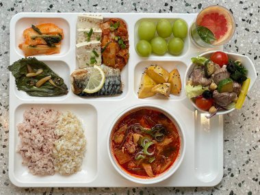 Masada kimçi, turşu sebze turşusu ve baharatlı sebzeler gibi çeşitli banchan (yan yemekler) içeren canlı bir Kore yemeği serpintisi. Yemek fotoğrafçılığı için mükemmel, geleneksel Korece sergileniyor..