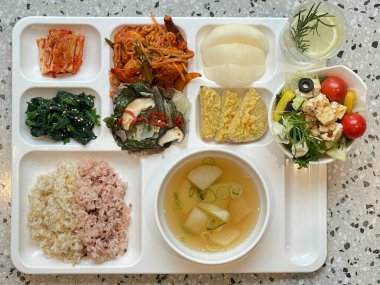 Masada kimçi, turşu sebze turşusu ve baharatlı sebzeler gibi çeşitli banchan (yan yemekler) içeren canlı bir Kore yemeği serpintisi. Yemek fotoğrafçılığı için mükemmel, geleneksel Korece sergileniyor..