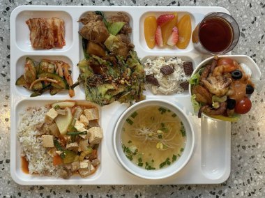 Masada kimçi, turşu sebze turşusu ve baharatlı sebzeler gibi çeşitli banchan (yan yemekler) içeren canlı bir Kore yemeği serpintisi. Yemek fotoğrafçılığı için mükemmel, geleneksel Korece sergileniyor..