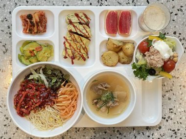 Masada kimçi, turşu sebze turşusu ve baharatlı sebzeler gibi çeşitli banchan (yan yemekler) içeren canlı bir Kore yemeği serpintisi. Yemek fotoğrafçılığı için mükemmel, geleneksel Korece sergileniyor..