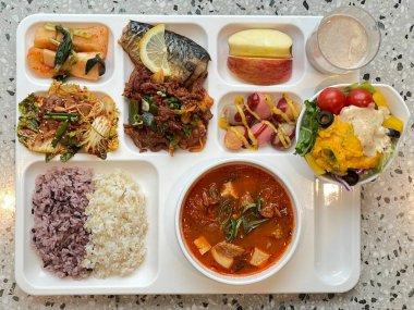 Masada kimçi, turşu sebze turşusu ve baharatlı sebzeler gibi çeşitli banchan (yan yemekler) içeren canlı bir Kore yemeği serpintisi. Yemek fotoğrafçılığı için mükemmel, geleneksel Korece sergileniyor..