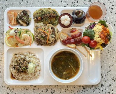 Masada kimçi, turşu sebze turşusu ve baharatlı sebzeler gibi çeşitli banchan (yan yemekler) içeren canlı bir Kore yemeği serpintisi. Yemek fotoğrafçılığı için mükemmel, geleneksel Korece sergileniyor..