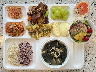 Masada kimçi, turşu sebze turşusu ve baharatlı sebzeler gibi çeşitli banchan (yan yemekler) içeren canlı bir Kore yemeği serpintisi. Yemek fotoğrafçılığı için mükemmel, geleneksel Korece sergileniyor..