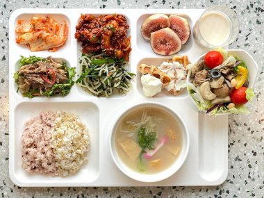 Masada kimçi, turşu sebze turşusu ve baharatlı sebzeler gibi çeşitli banchan (yan yemekler) içeren canlı bir Kore yemeği serpintisi. Yemek fotoğrafçılığı için mükemmel, geleneksel Korece sergileniyor..